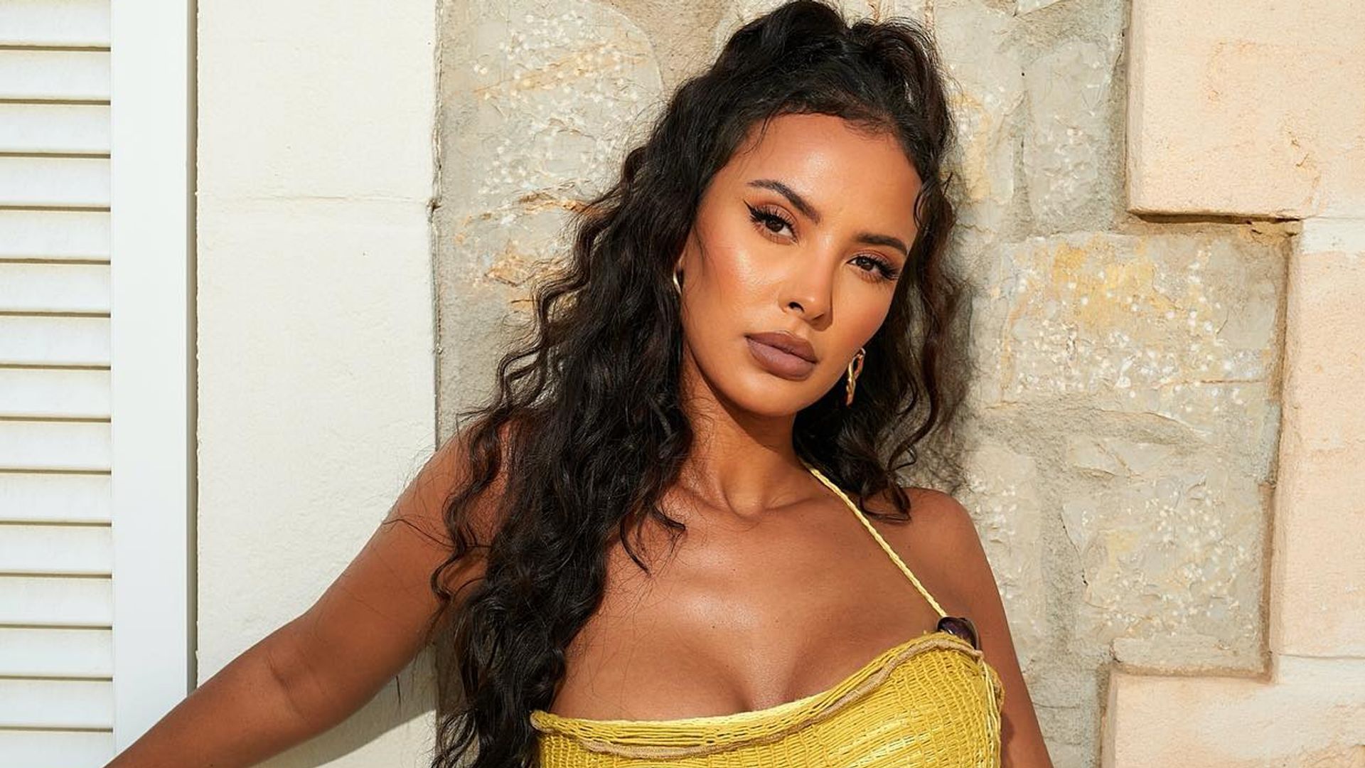 Maya Jama poses for a picture in a sheer yellow dress