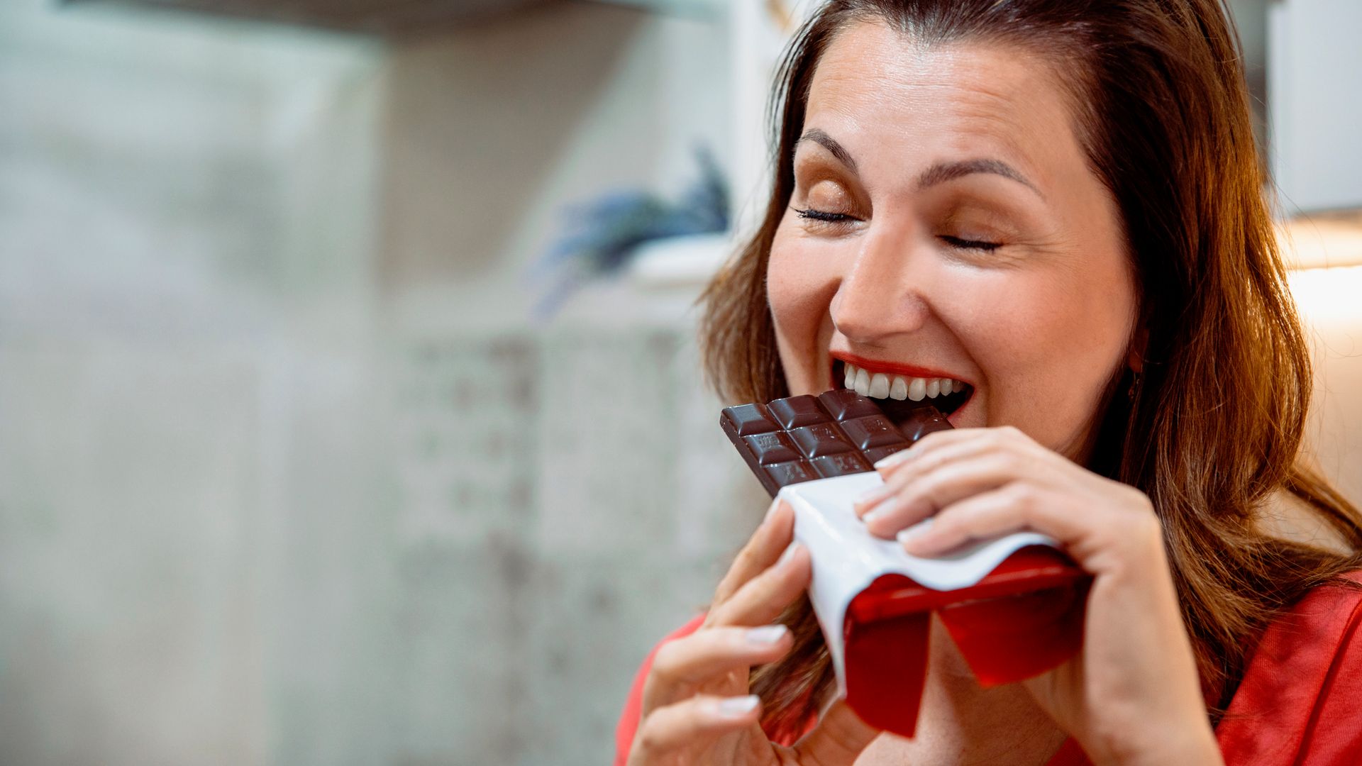 woman eating chocolate with her eyes closed.j