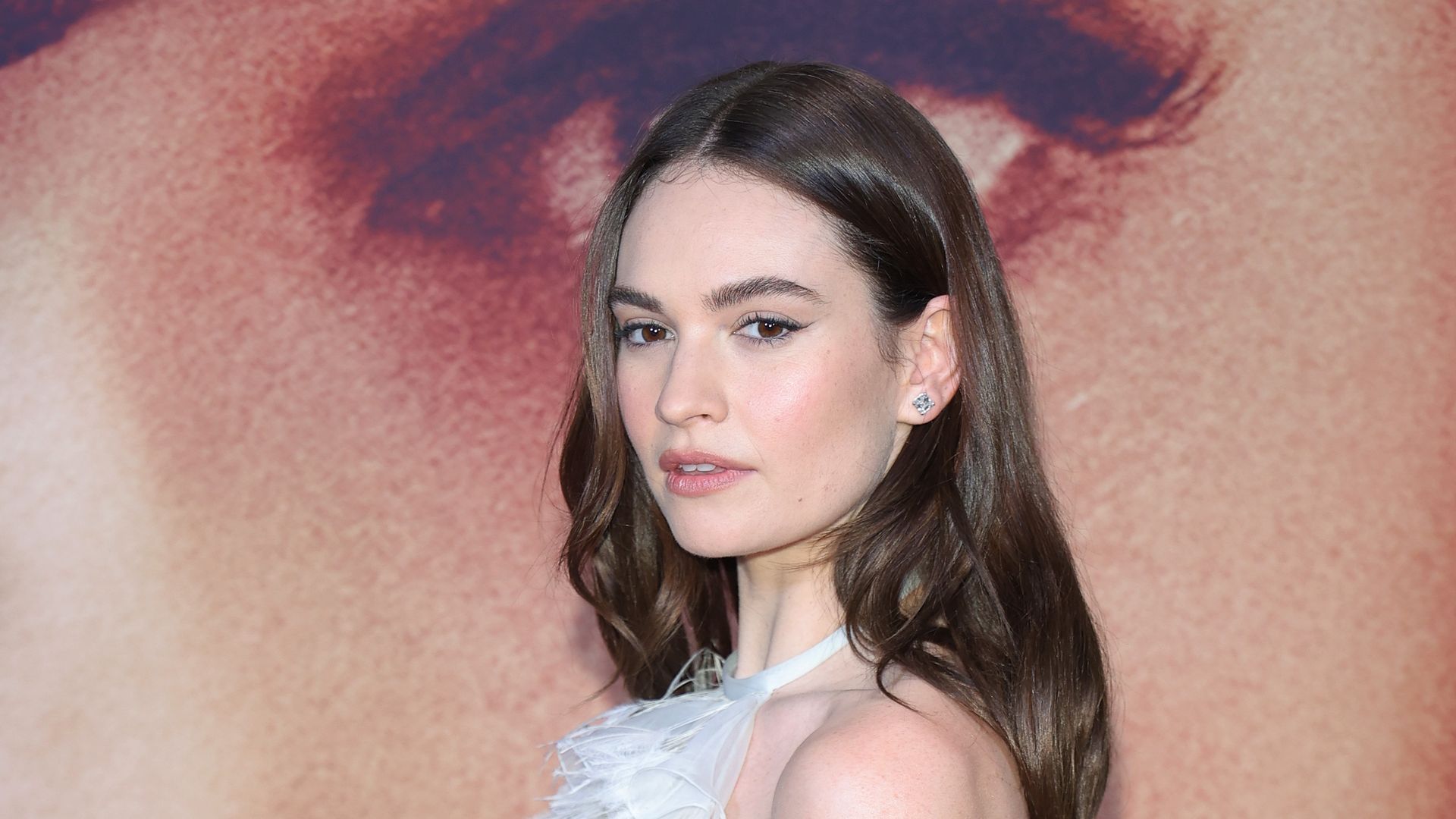 Lily James’ cosy coat and snake print boot combo is completely It-girl-coded