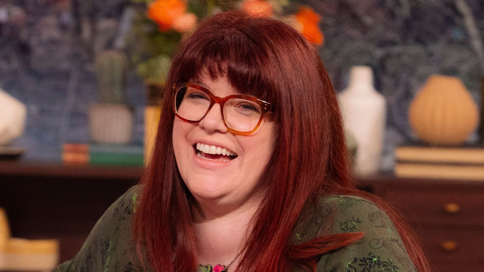 Woman with red hair sitting on blue sofa