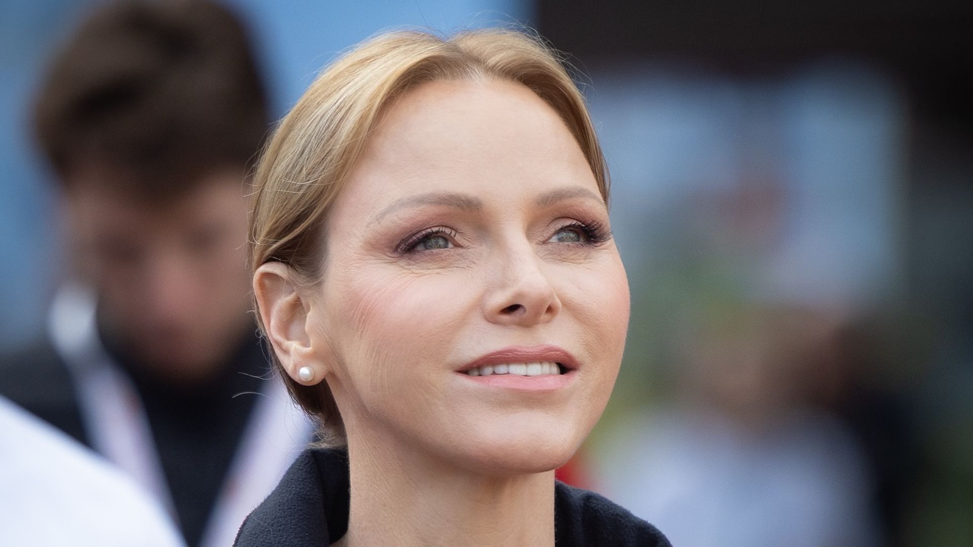 princess charlene smiling to sky in red coat