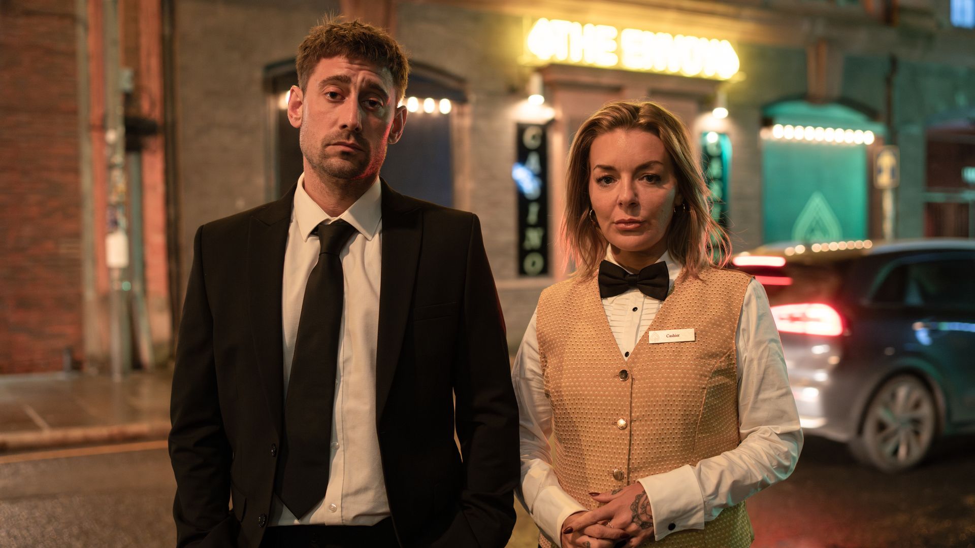 man and woman in suits outside casino