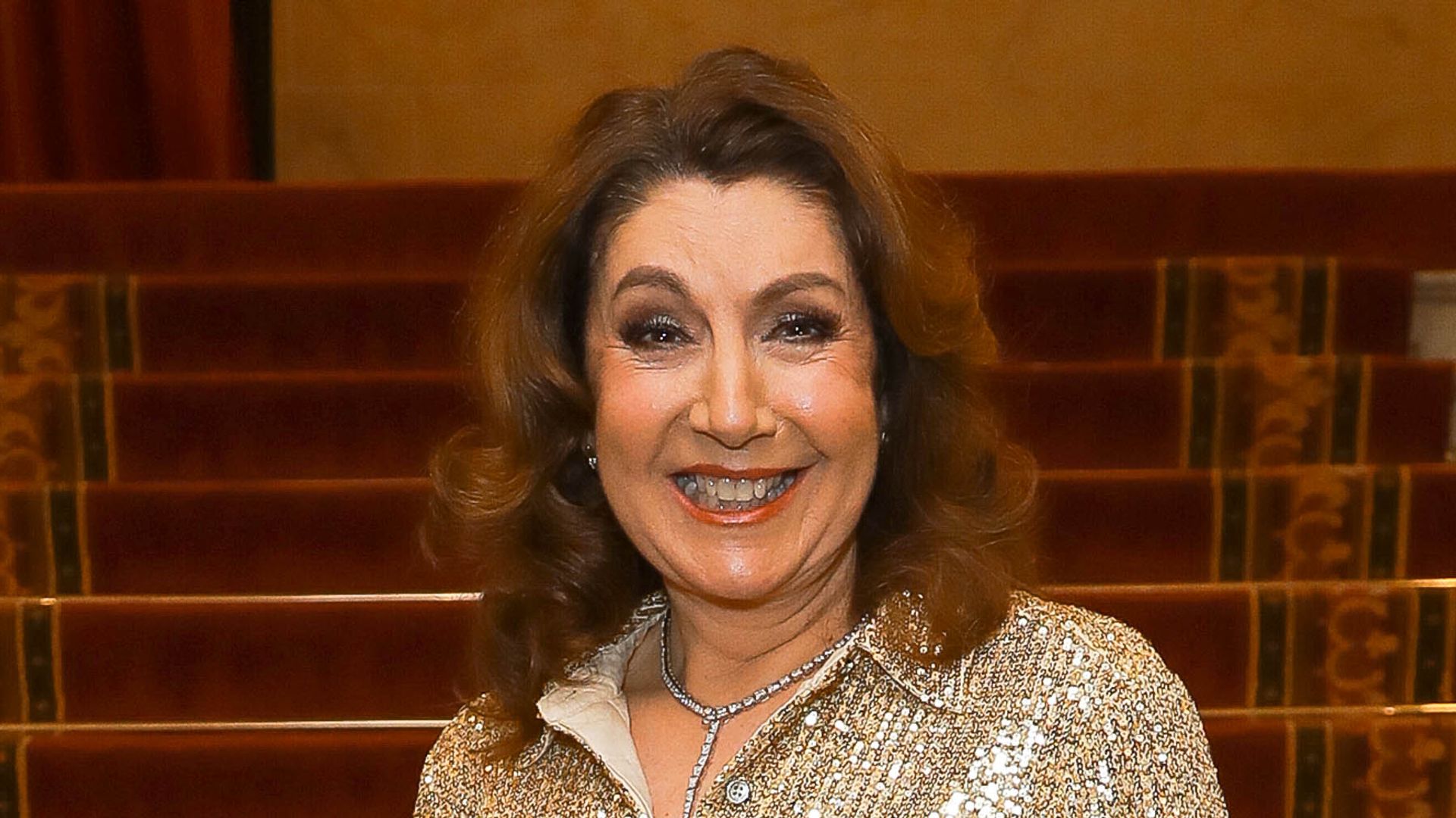 Jane McDonald smiling in a gold sequin jumper