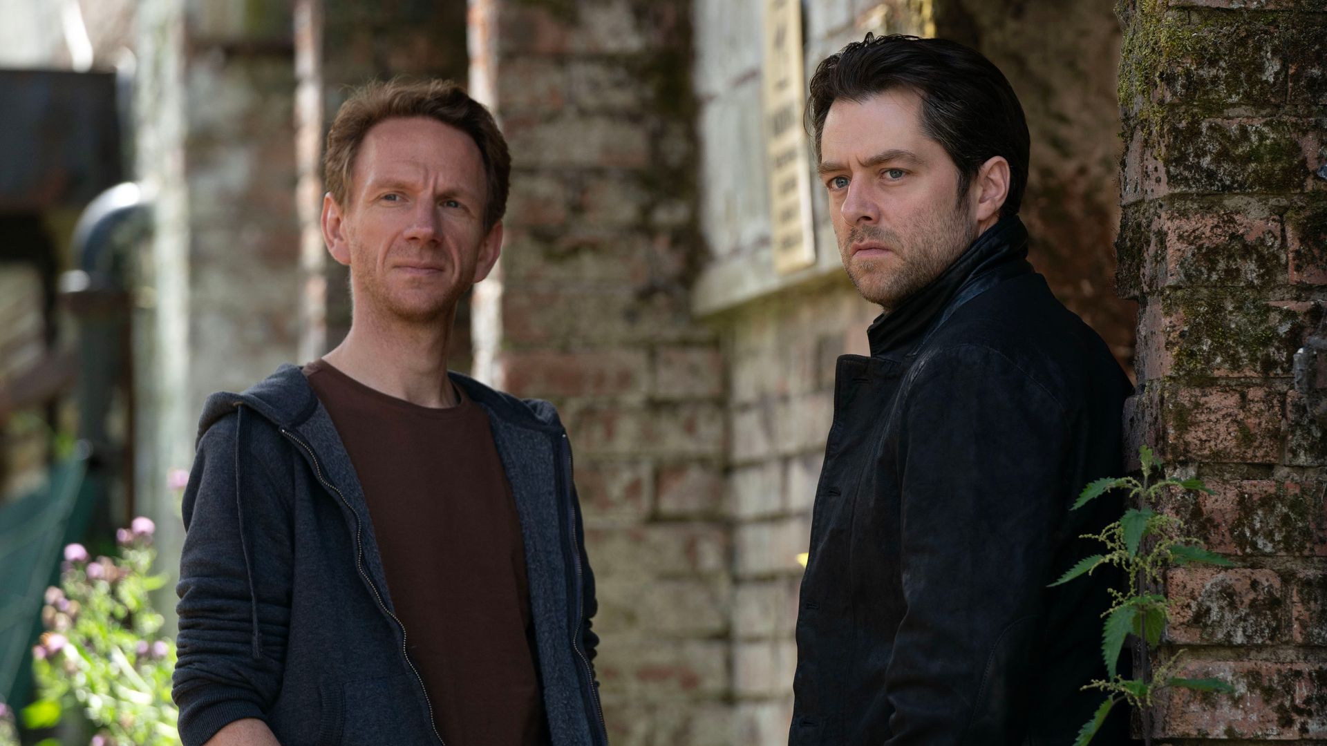 two men standing outside building