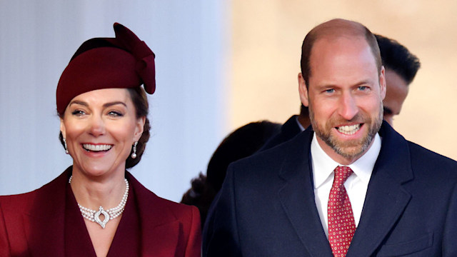 Kate Middleton in red outfit and Prince William in a blue suit