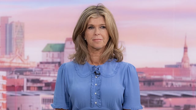 Kate Garraway looking serious in a blue dress whilst presenting GMB