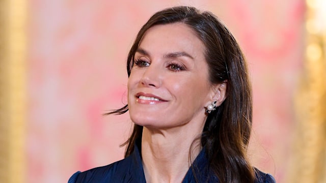 Queen Letizia of Spain smiling in blue outfit