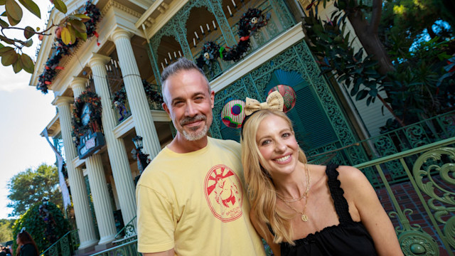 Freddie Prinze Jr. and Sarah Michelle Gellar pose in front of Haunted Mansion Holiday at Disneyland Park, while visiting the park with their family 