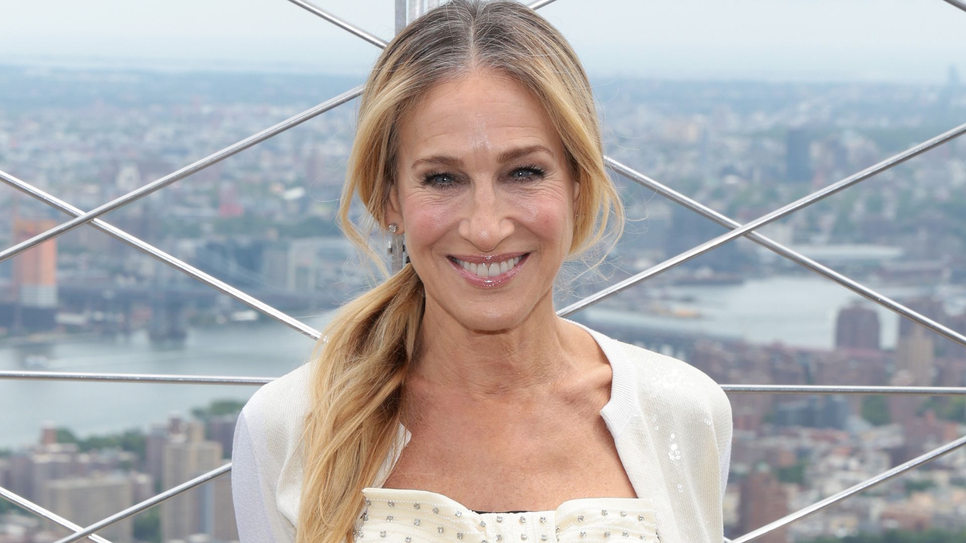 Sarah Jessica Parker smiling at the top of the empire state building