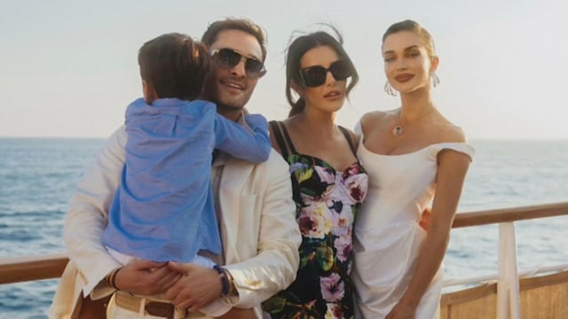 Ed Westwick holding a baby while with a friend and Amy Jackson