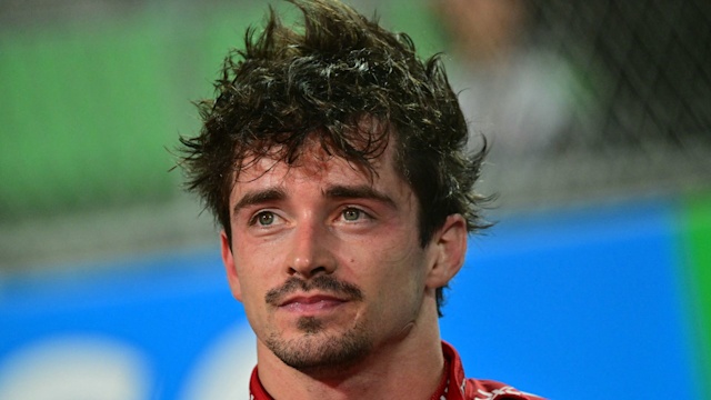 Charles Leclerc with messy hair in a Ferrari race suit