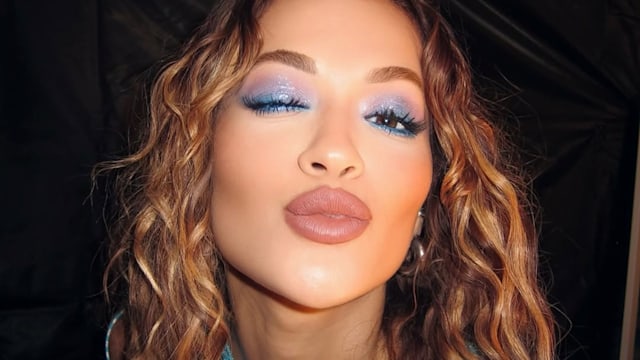 rita ora looking towards the camera with blue eyeshadow 