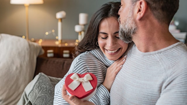 Romantic couple at home. Men giving a present to his girlfriend