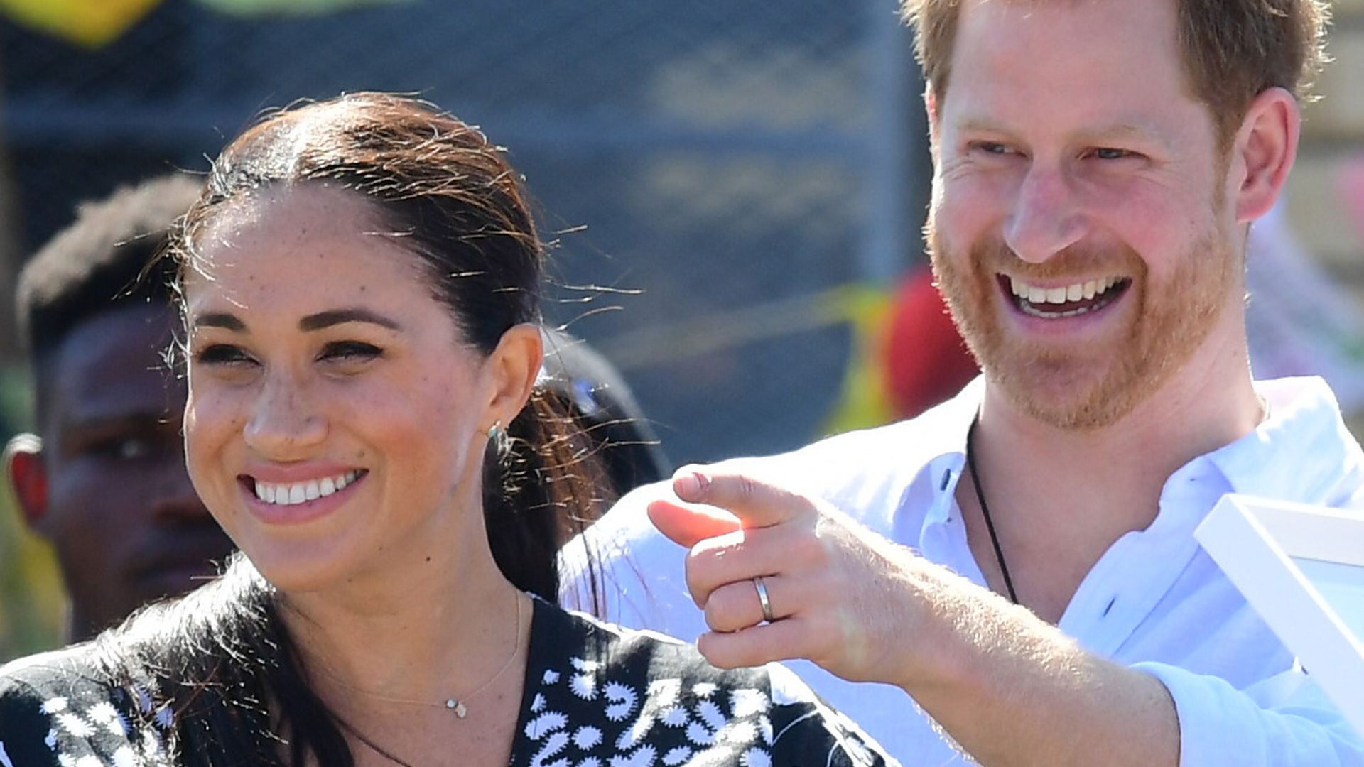 prince harry pointing and meghan markle smiling
