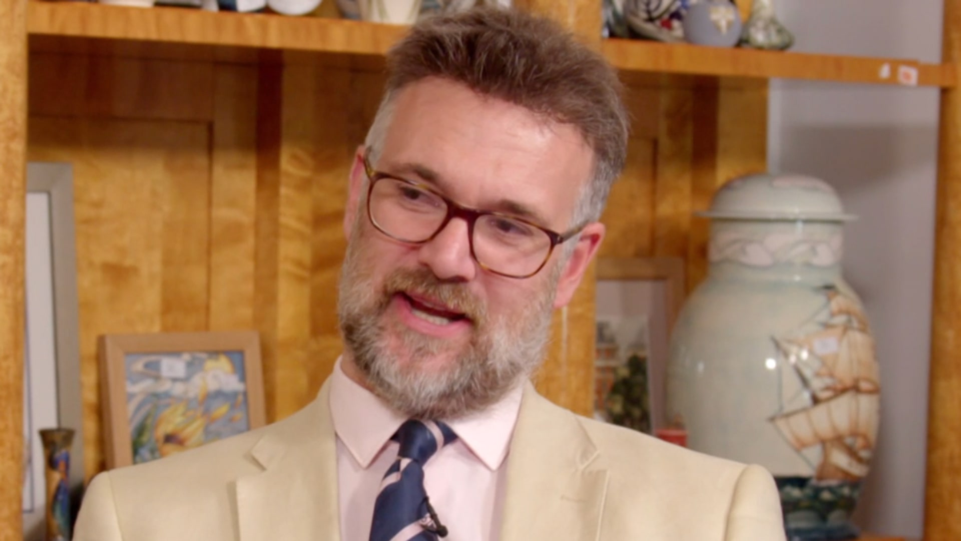 man in white suit with glasses