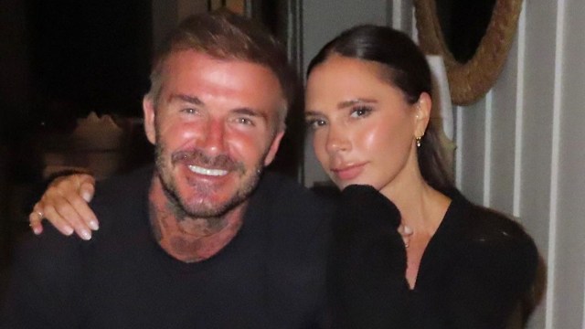 David and Victoria Beckham cuddling at dinner table