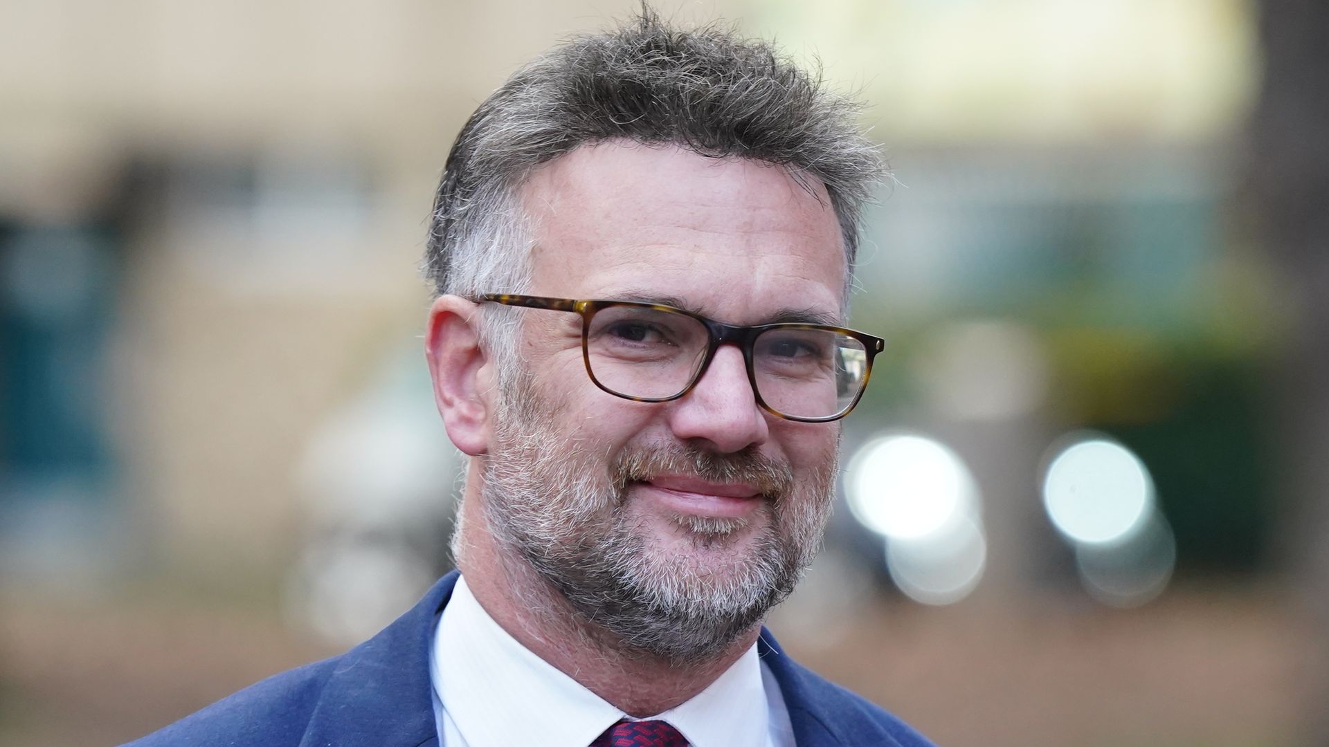 close-up of man with beard in suit smiling
