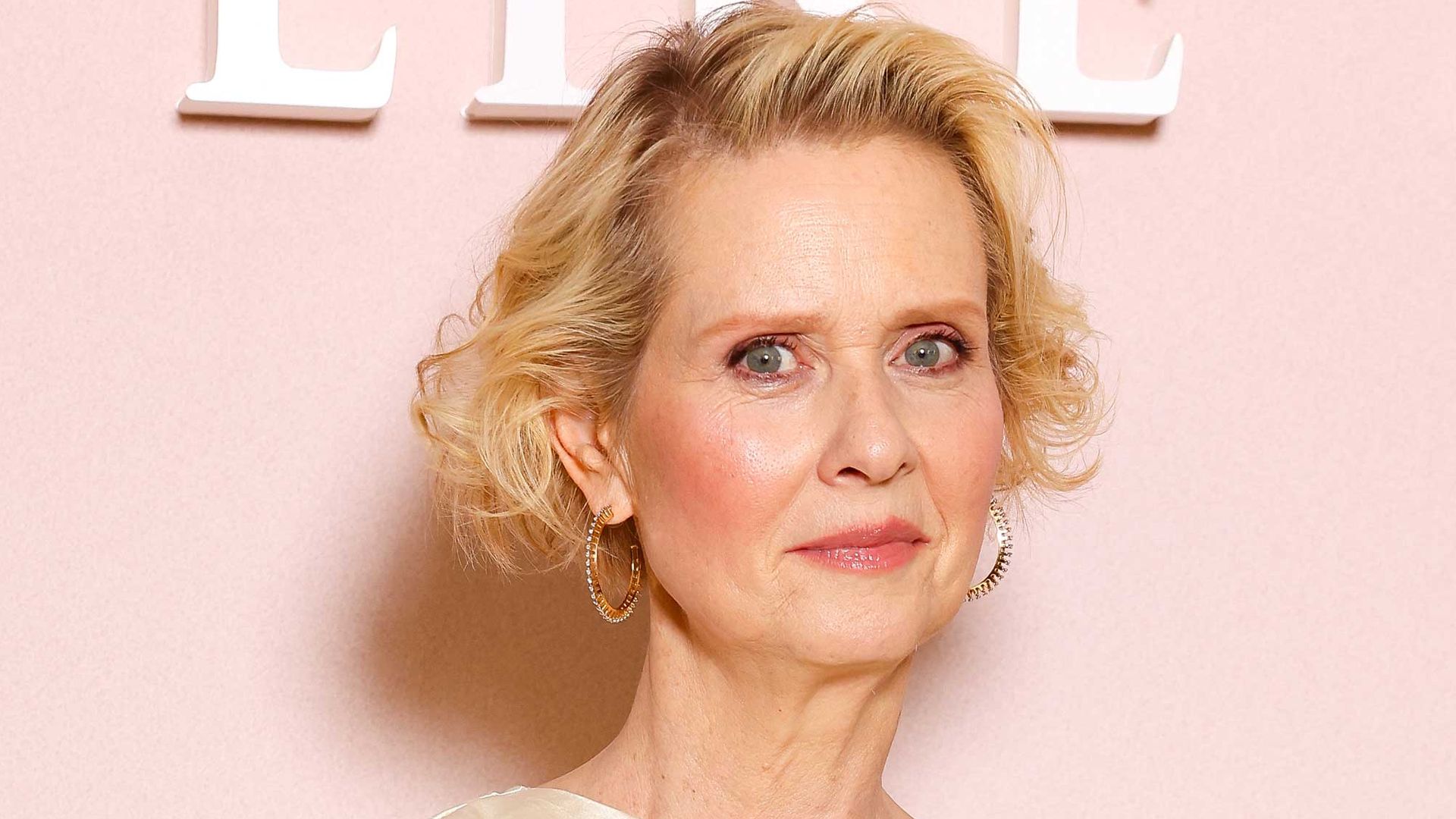 Cynthia Nixon on red carpet in white dress