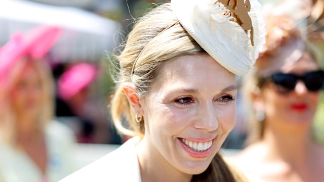 Carrie Johnson smiling in a white outfit