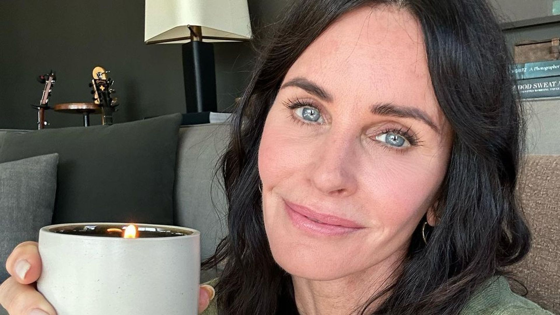Courteney Cox holds up a candle