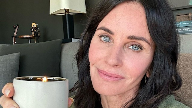 Courteney Cox holds up a candle