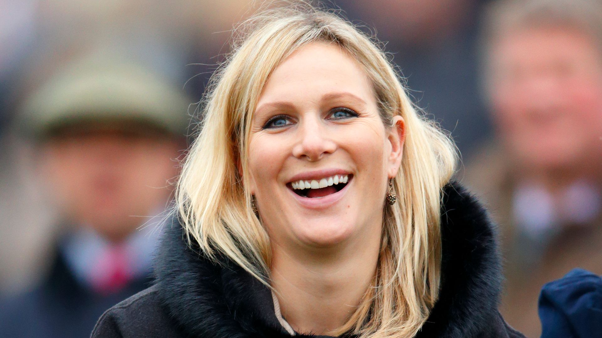 Zara Phillips smiling in blue poncho