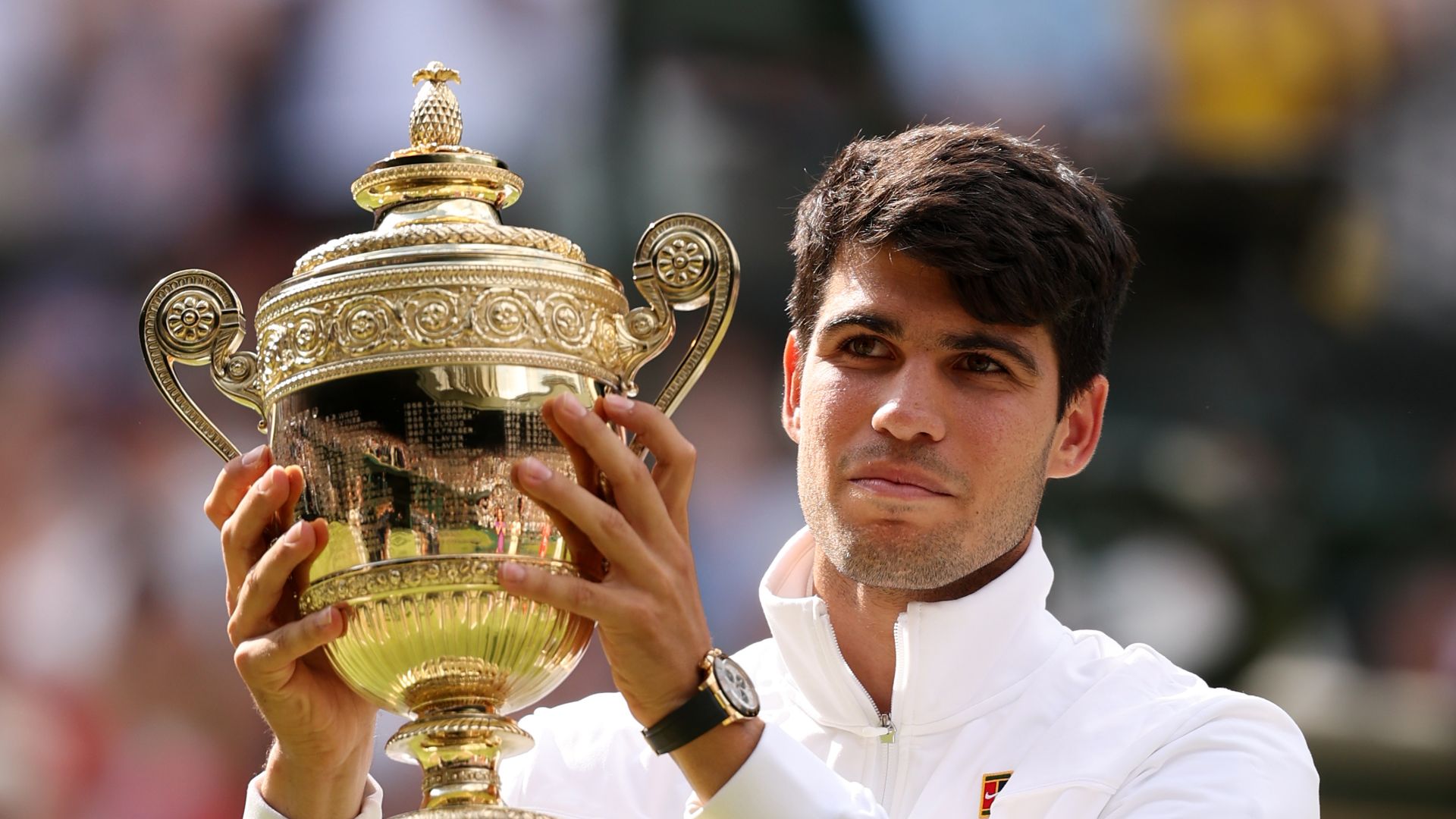 carlos alcaraz holding trophy at wimbledon in 2024