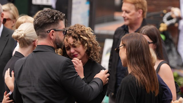 Jack Osbourne and Pearl Osbourne stopping to view tributes to the late Ozzy Osbourne from fans at Black Sabbath Bench and Bridge as his funeral cortege travels through his home city of Birmingham on July 30, 2025 in Birmingham, England. The Black Sabbath frontman passed away on July 22nd at the age of 76. His death occurred just a little over two weeks after his final live performance at the 'Back to the Beginning' concert in his hometown of Birmingham. (Photo by Christopher Furlong/Getty Images)