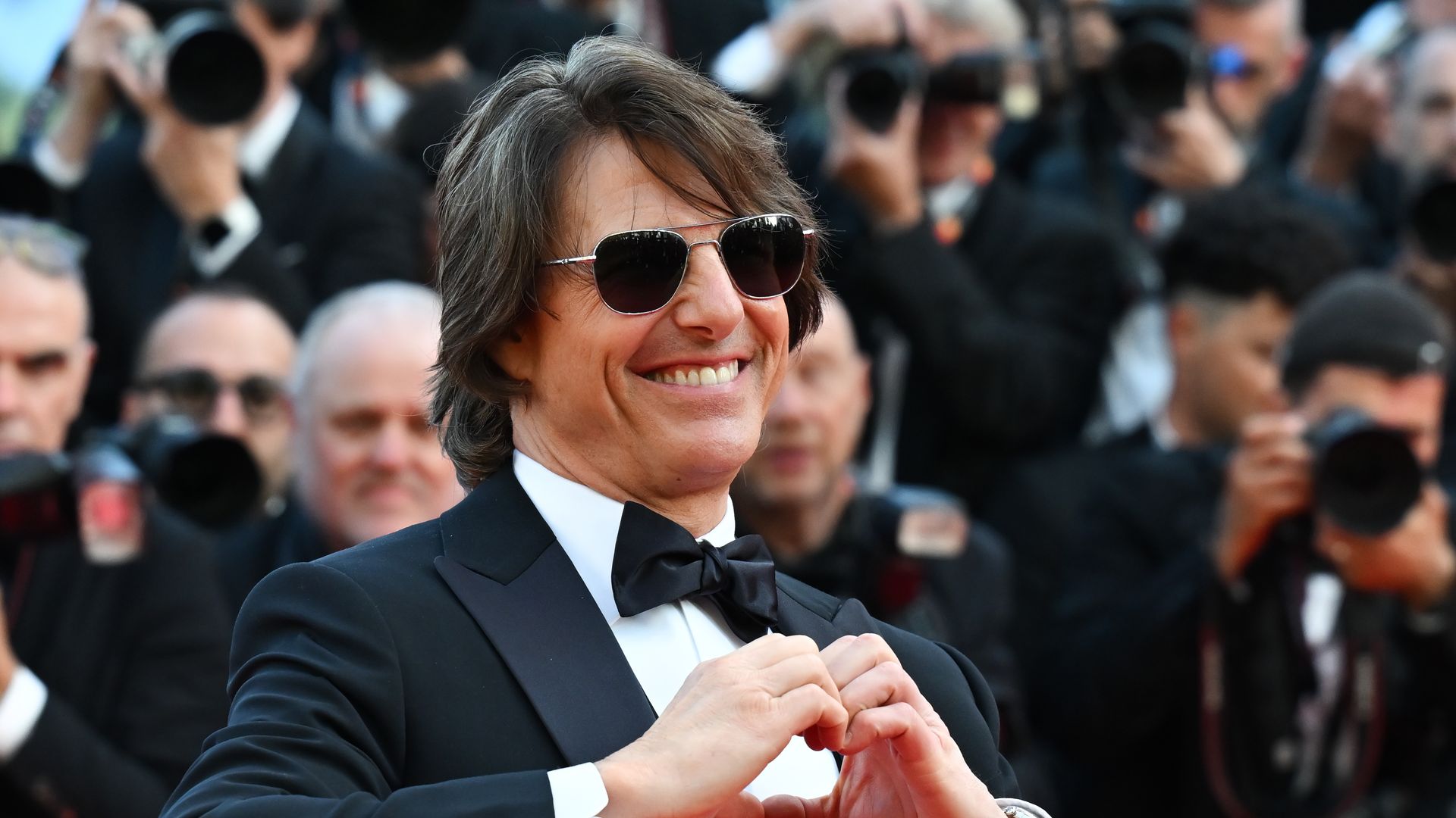 Tom Cruise making a heart shape with his hands