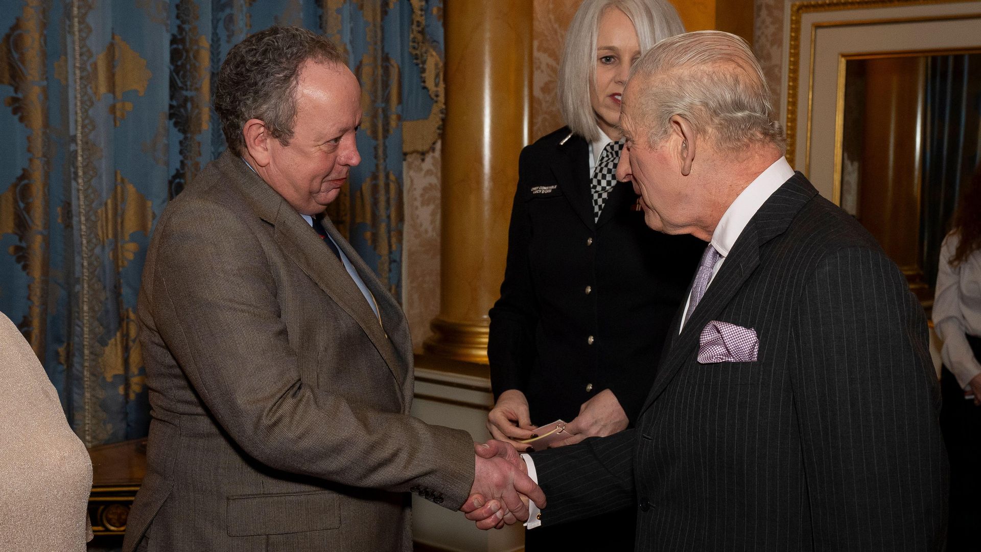 King Charles shaking hands with a man
