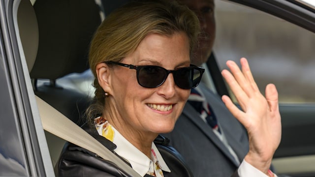 Sophie Duchess of Edinburgh waves out the car window as she wears a leather jacket and sunglasses