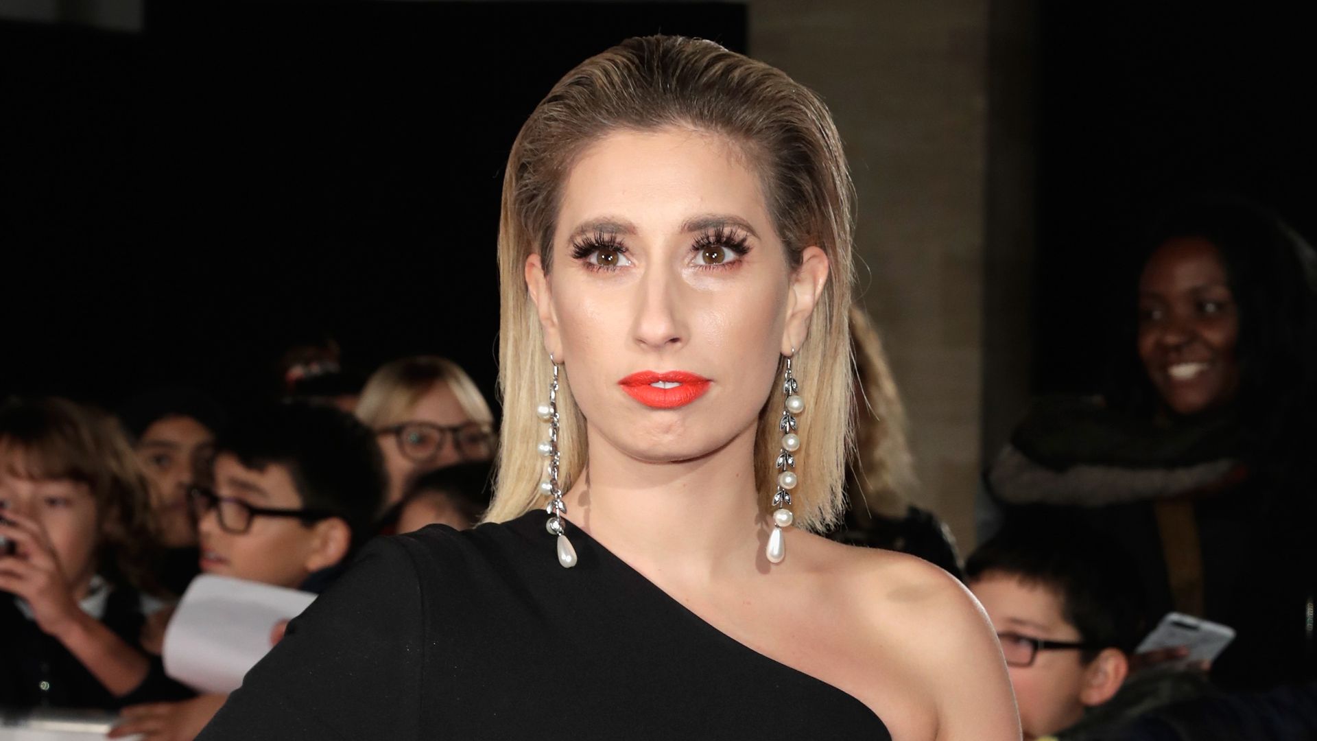 Stacey Solomon in a black dress with one shoulder exposed
