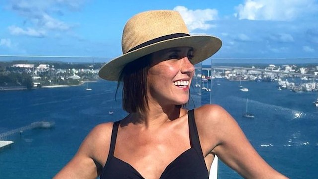 Pregnant Janette Manrara in black swimsuit posing in pool on cruise ship