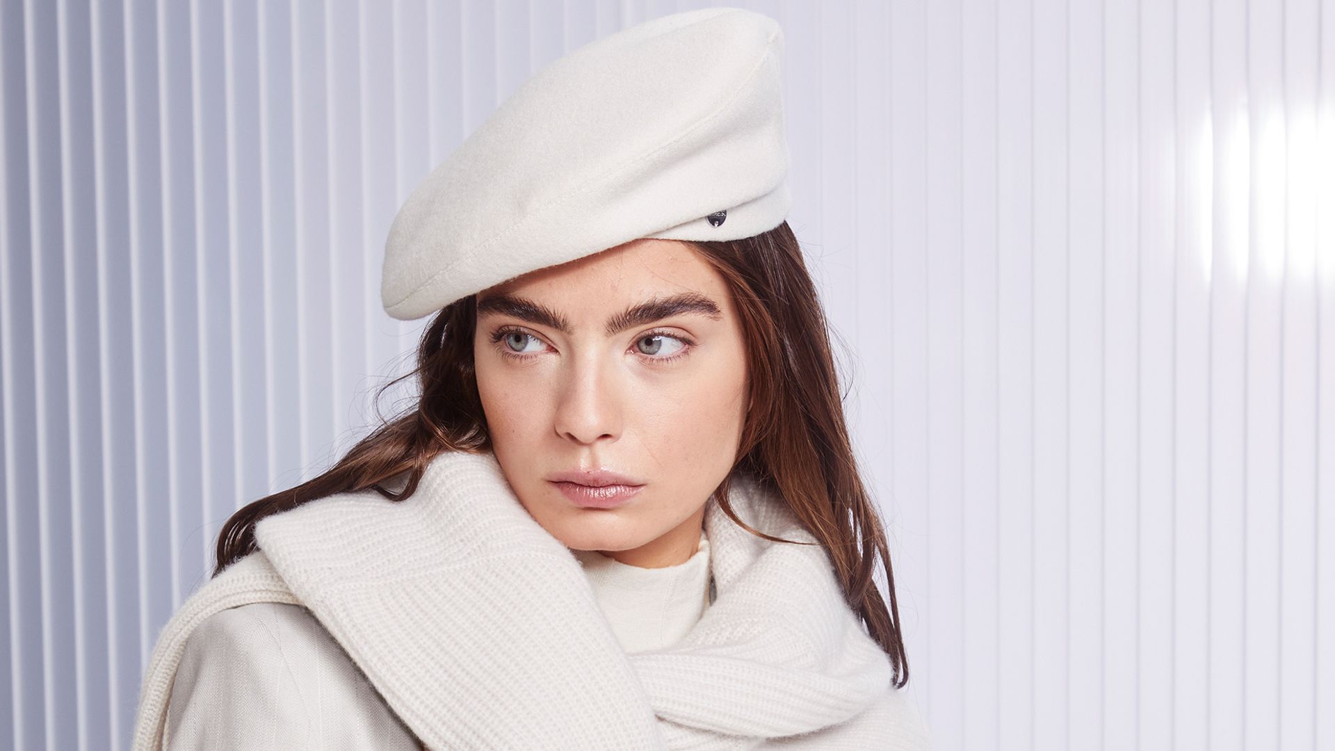 Marc Cain model poses in a white Beret, sweater and suit for fall/winter 2024 collection titled ‘Blend Boundaries’