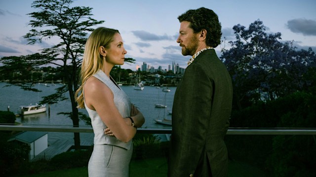 A woman and man looking at each other on balcony