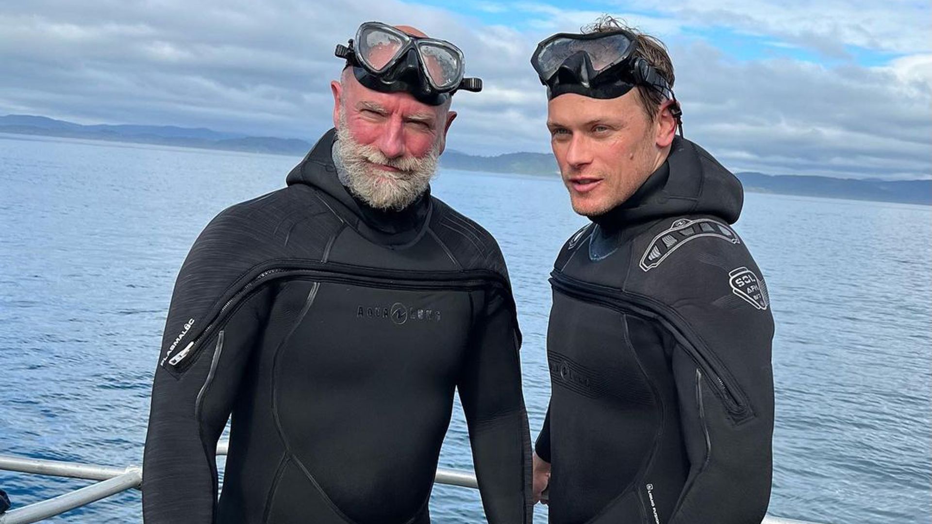 Sam Heughan and Graham McTavish in wetsuits 