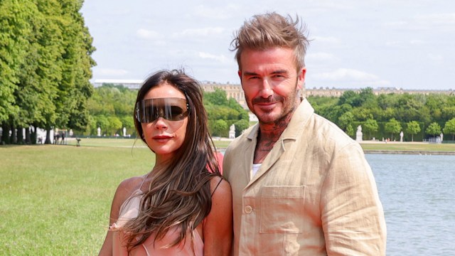 Victoria Beckham and David Beckham in a park by a lake