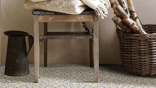 Moroccan tiles, a wicker basket and a chair with folded towels and blankets above