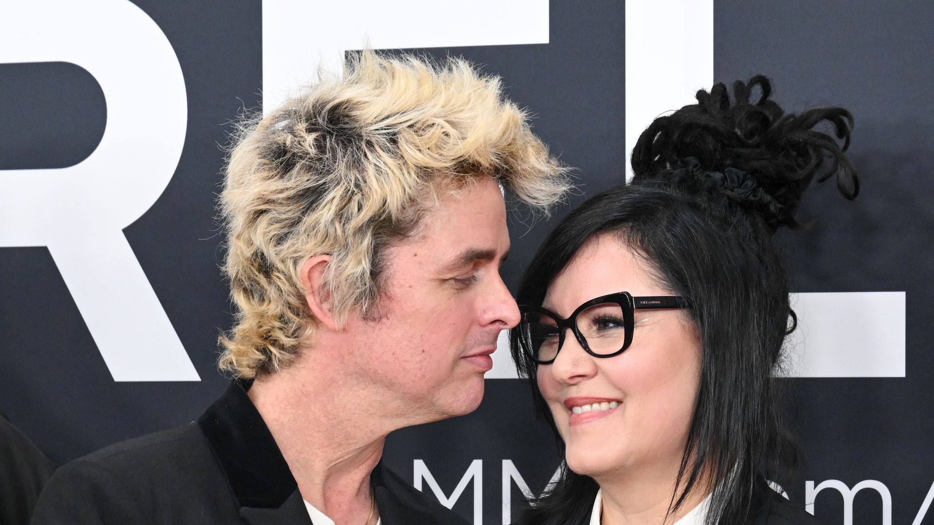 Billie Joe Armstrong in black blazer Adrienne Armstrong in white shirt at the 67th GRAMMY Awards held at the Crypto.com Arena on February 2, 2025 