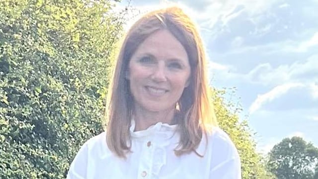 Geri Horner posing in khaki shorts and white vest at home