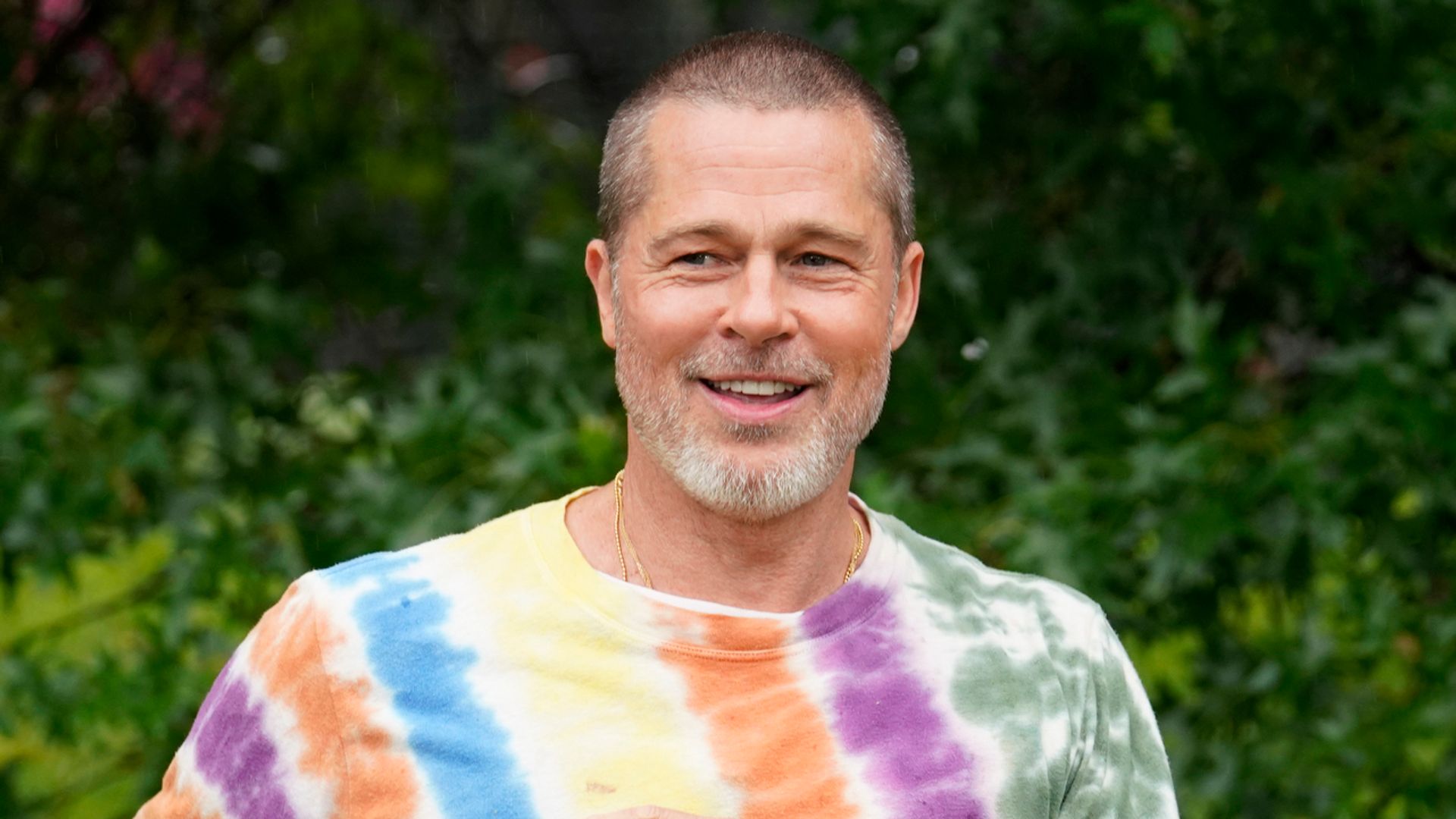 brad pitt in tie dye outfit holding a frisbee
