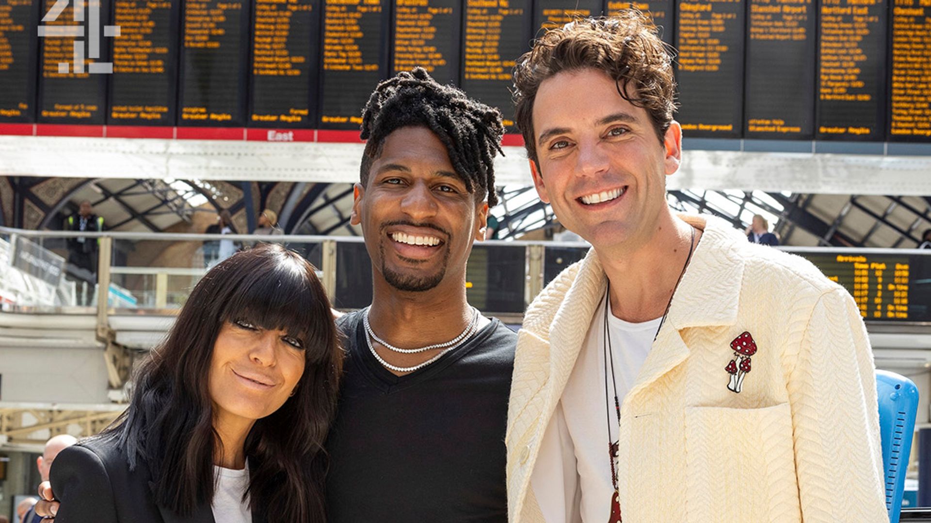 a woman and two men standing in train station