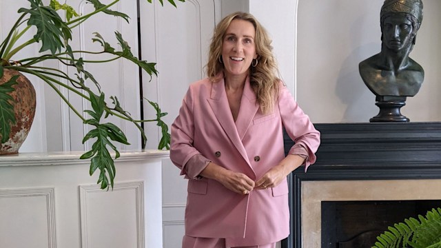 Woman smiling in a pink suit