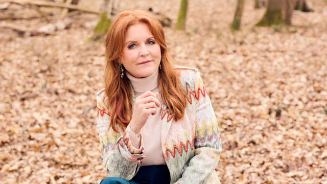 Sarah Ferguson sitting in a wood, wearing jeans and a cardigan