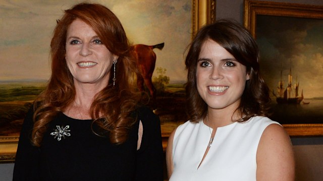 Sarah ferguson in a black dress standing with Princess Eugenie in a white dress