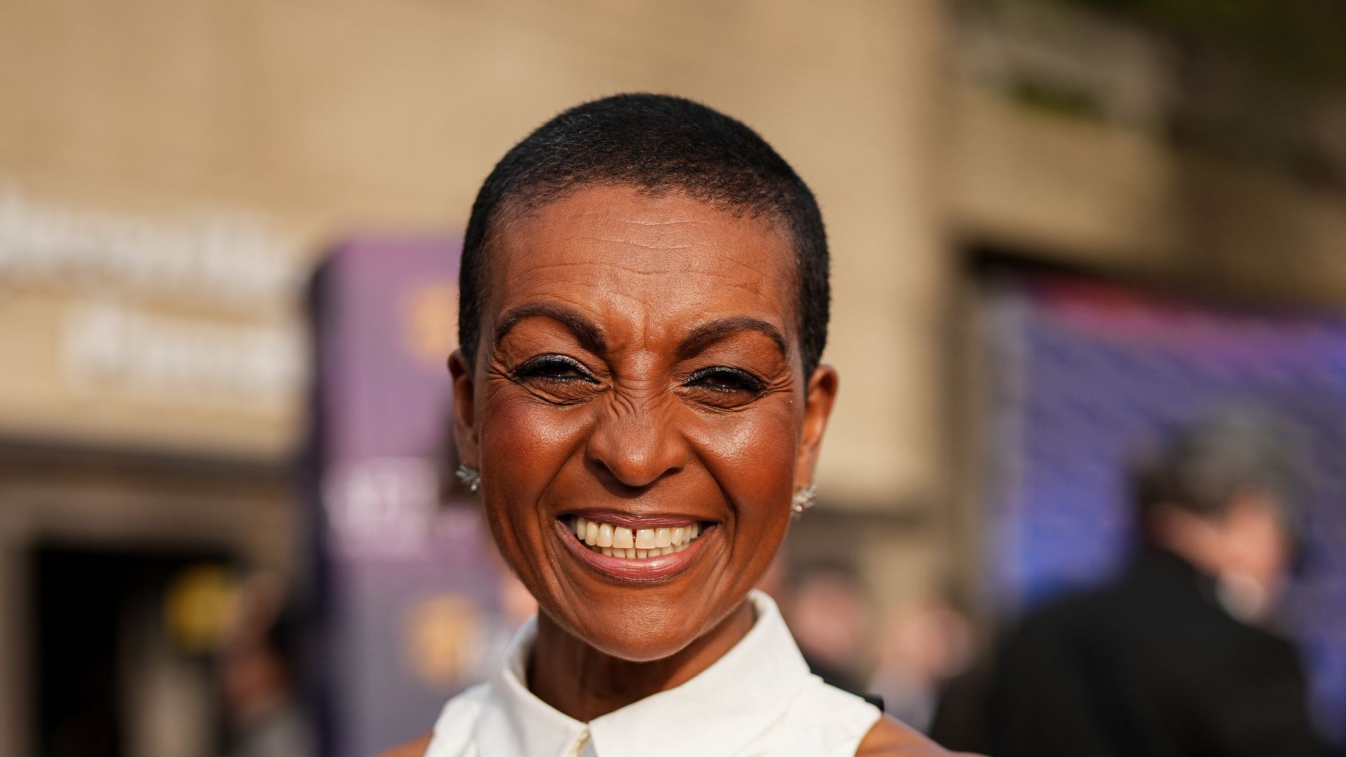 Adjoa Andoh smiling in sleeveless black and white dress
