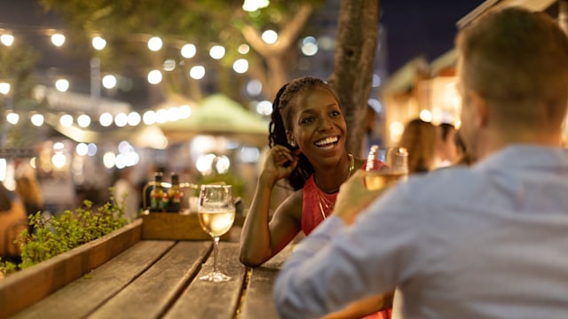 Couple drinking wine together outdoors at night