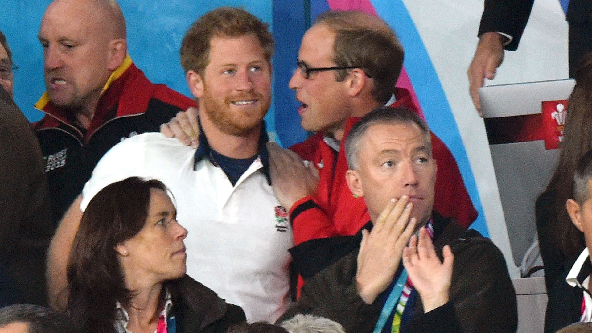 Prince William speaking into Prince Harry's ear