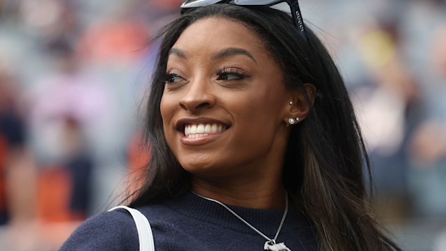 Gymnast Simone Biles stands on the sideline before the football game between the Los Angeles Rams and the Chicago Bears at Solider Field on September 29, 2024 in Chicago, Illinois.