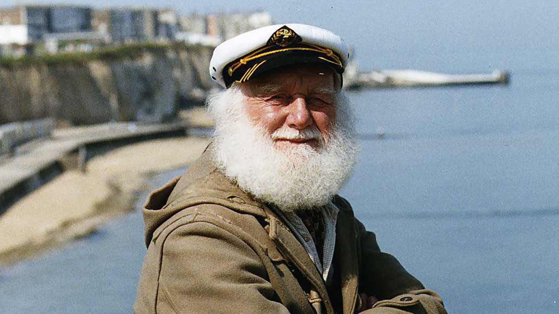 Buster Merryfield sitting with his arms crossed on the side of cliffs
